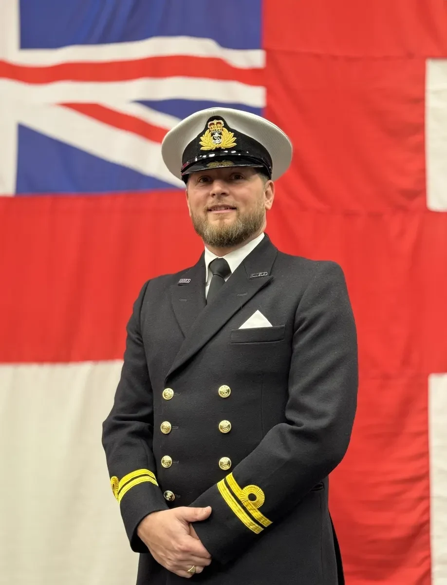 In my naval uniform in front of the White Ensign